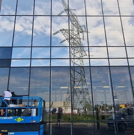 Montage van spiegelende raamfolie op glazen gevel van kantoorpand Division