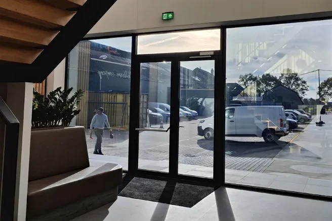 Zonwerende raamfolie op glazen entree van kantoorpand voor comfortabel binnenklimaat